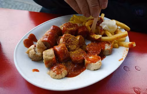 Xúc xích heo được nướng, hoặc hun khói, chiên lên. Sau đó cắt lát rưới nước xốt cà ri, tương ớt lên.