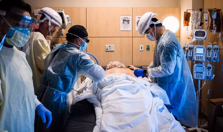 Các bác sĩ đang chuẩn bị chuyển một bệnh nhân Covid-19 vào phòng ICU. Ảnh: Bloomberg.