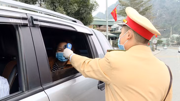 Công an TP Cẩm Phả vừa điều tiết giao thông kết hợp với đo nhiệt độ người tham gia giao thông. 