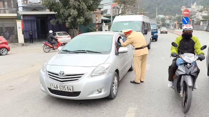 Lực lượng CSGT điều tiết phương tiện và kiểm tra thân nhiệt lái xe trên QL18, đoạn đi qua địa bàn TP Hạ Long. 