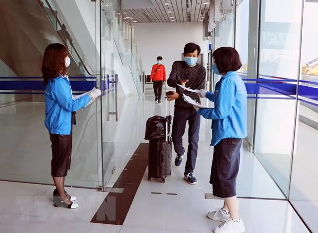 Lực lượng thanh niên tình nguyện hỗ trợ khai báo thông tin y tế. (Ảnh: Hoàng Ngọc/TTXVN)