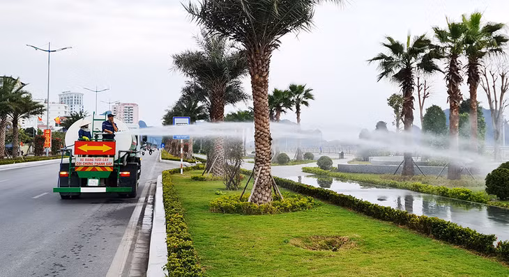 Nhân viên Công ty cây xanh công viên Quảng Ninh tưới nước chăm sóc cây xanh trên tuyến đường bao biển Hạ Long.