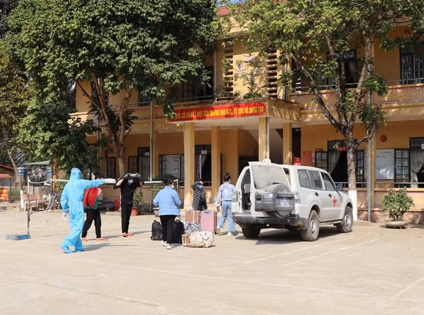 Huyện Mường Ảng đưa các trường hợp cách ly đến khu cách ly tập trung. (Ảnh: Xuân Tiến/TTXVN)
