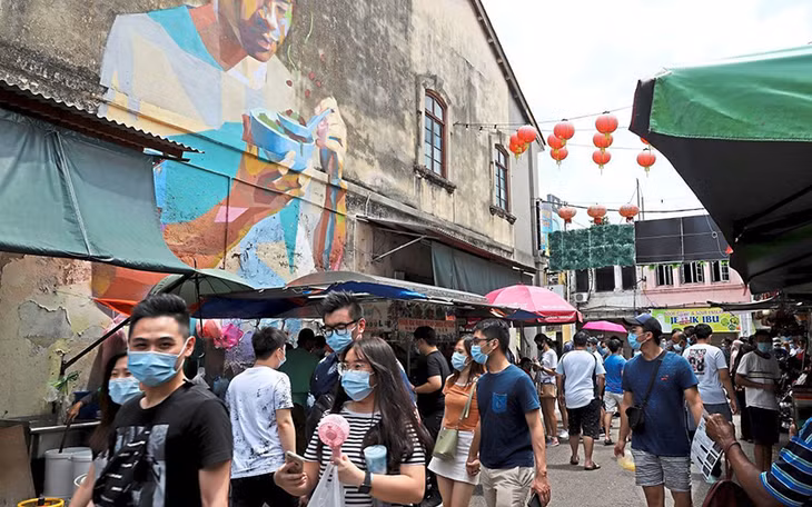 Du khách đeo khẩu trang phòng dịch tại bang Pê-nang của Ma-lai-xi-a.