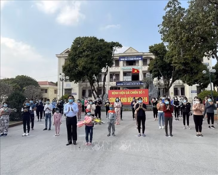 Lãnh đạo thành phố Chí Linh, Hải Dương tặng hoa, chúc mừng các bệnh nhân đã khỏi bệnh tại Bệnh viện Dã chiến số 1, chiều 21/2/2021. (Ảnh minh họa: TTXVN)