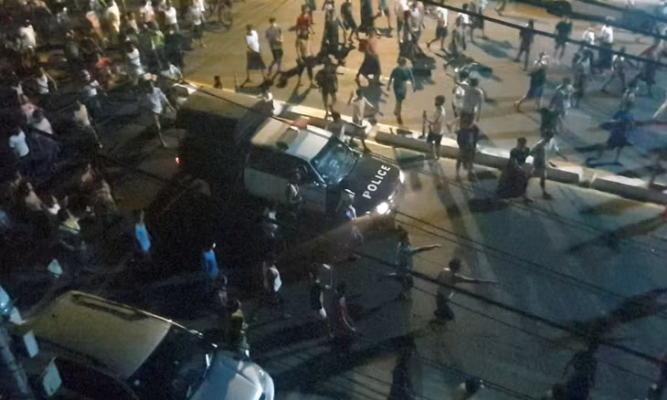 Người biểu tình bao vây một xe cảnh sát tại Yangon, Myanmar, hôm 12/2. Ảnh: Reuters.