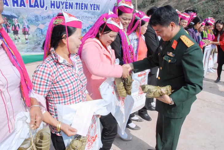 Đại diện LLVT huyện tặng bánh chưng cho người dân thôn Khe Lẹ ăn tết.