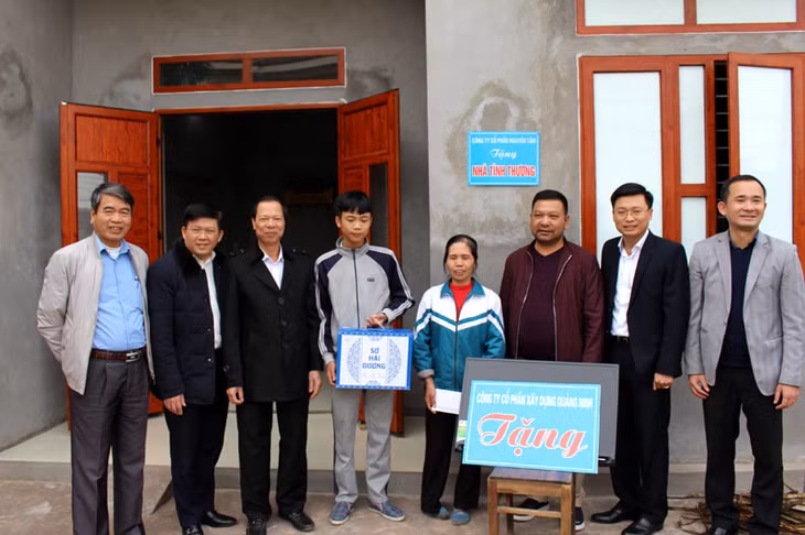 Các doanh nghiệp trao tiền hỗ trợ bà Lê Thị Hường là hộ nghèo, khuyết tật ở xã Đầm Hà xây nhà mới.