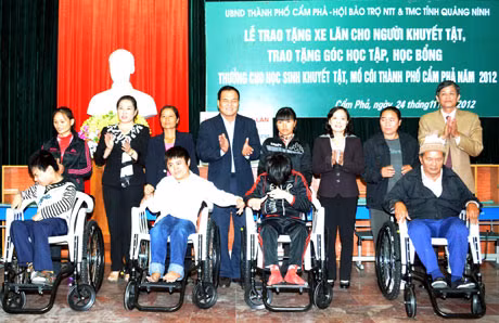 Lãnh đạo Hội BTNTT và TMC tỉnh cùng lãnh TP Cẩm Phả trao xe lăn cho người khuyết tật.