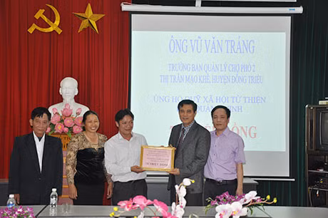 Ông Vũ Văn Tráng, Trưởng Ban Quản lý chợ khu 2, thị trấn Mạo Khê (Đông Triều) trao số tiền 70 triệu đồng ủng hộ Quỹ Từ thiện Nhân đạo của Báo Quảng Ninh.
