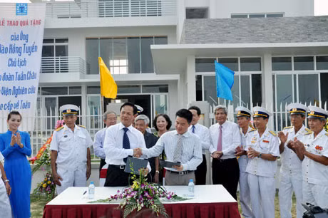Ông Đào Hồng Tuyển (bên trái) trao tặng Viện Toán học cao cấp ngôi biệt thự trị giá 3 triệu USD trên đảo Tuần Châu cho đại diện của Viện, giáo sư Ngô Bảo Châu (bên phải).