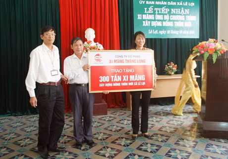Ông Nguyễn Hữu Phương, Phó Tổng Giám đốc Công ty CP Xi măng Thăng Long (bên trái) trao tặng 300 tấn xi măng cho xã Lê Lợi.