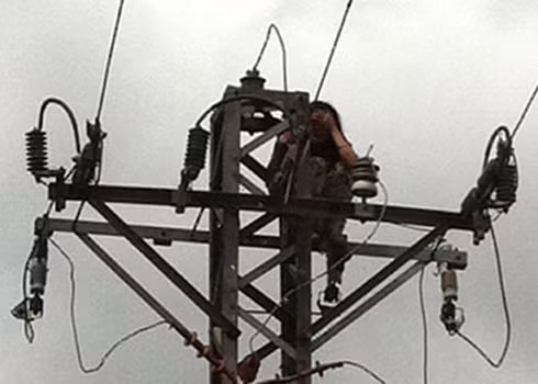 Cô gái ngồi trên trụ điện cao thế. Ảnh: Quốc Dũng.