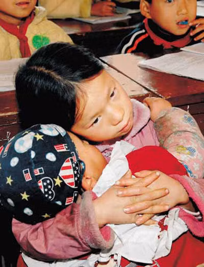 Cô bé Ning Yexiang bồng em đến lớp (Ảnh: Beijing Times)