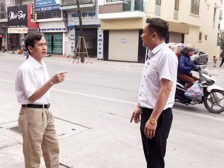 Phó trưởng Phòng Quản lý đô thị TP Uông Bí Nguyễn Văn Thọ (bên phải) trò chuyện, lắng nghe ý kiến phản ánh của người dân về cuộc thi “Tuyến phố trật tự đô thị - ATGT”.