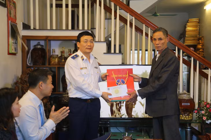 Thiếu tướng Doãn Bảo Quyết, Phó Chính ủy Cảnh sát biển Việt Nam tặng quà cho ông Lê Xuân Thanh, thương binh hạng ¾ trú tại khu 3, thị trấn Cô Tô.