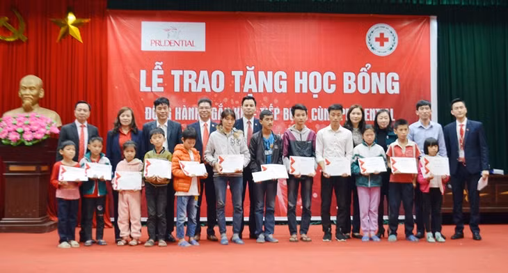 Lãnh đạo Công ty Prudential và Hội Chữ thập đỏ tỉnh trao tặng các suất học bổng cho các em học sinh nghèo hiếu học tại phương Minh Thành (TX Quảng Yêu).