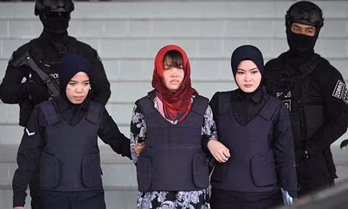 Cảnh sát áp giải Đoàn Thị Hương bên ngoài tòa án ở Kuala Lumpur, Malaysia hôm 14/3. Ảnh: AFP.