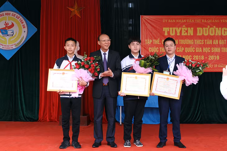 Đồng chí Trần Đức Thắng, Phó Bí thư Thị ủy, Chủ tịch UBND thị xã khen thưởng cho thầy giáo Hoàng Văn Thắng, em Ngô Anh Tài, Nguyễn Đức Hoàn, trường THCS Tân An
