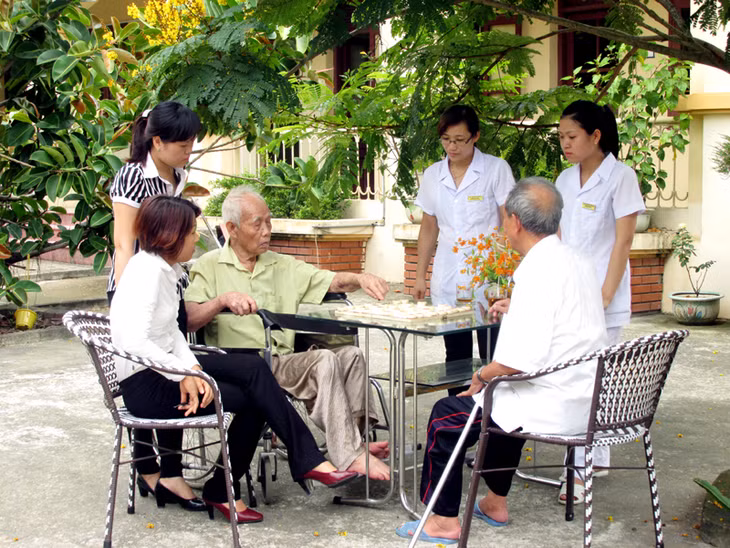 Cán bộ ở Trung tâm đang cùng chơi cờ với các cụ.