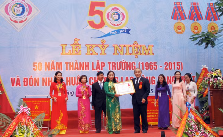 Đồng chí Nguyễn Vinh Hiển, Thứ trưởng Bộ GD và ĐT trao Huân chương Lao động hạng Nhất cho nhà trường.