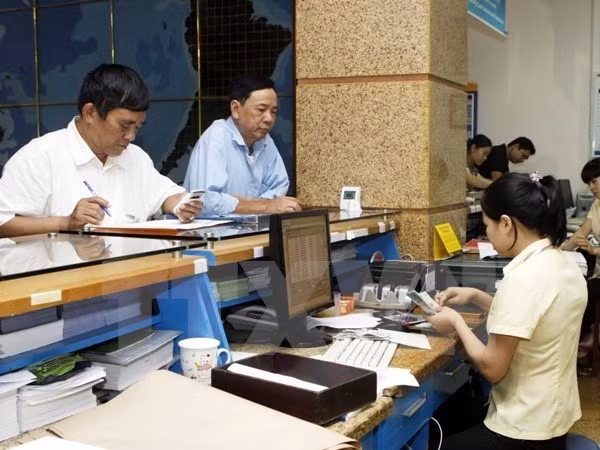 Nhận lương hưu tại bưu điện. (Nguồn: TTXVN)