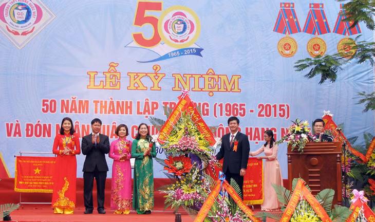 Đồng chí Lê Quang Tùng, Phó Chủ tịch UBND tỉnh trao bức trướng của Tỉnh ủy-HĐND-UBND tỉnh và tặng hoa chúc mừng nhà trường.