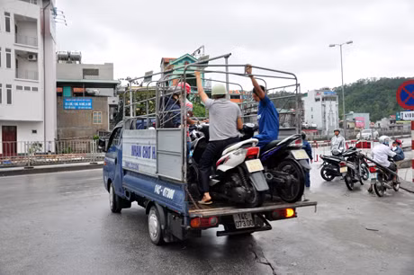 Lực lượng chức năng bố trí xe tải đưa người dân qua cầu để đảm bảo an toàn.
