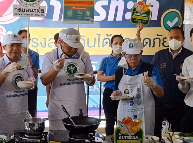 Tỉnh trưởng tỉnh Samut Sakhon, ông Veerasak Vijitsaengsri (bên trái, đeo kính) là ca mắc Covid-19 mới nhất vừa được phát hiện. Ông đứng cạnh Bộ trưởng Y tế Cộng đồng Anutin Charnvirakul trong một hoạt động hôm 27/12. Ảnh: Khaosod.