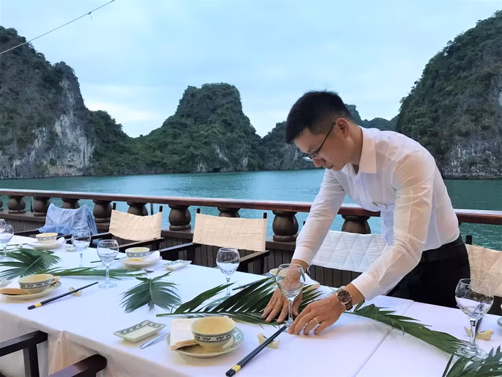 Chất lượng dịch vụ được các doanh nghiệp kinh doanh đảm bảo, đáp ứng nhu cầu của du khách. Trong ảnh: Nhân viên tàu nghỉ đêm Dragon Legend bày trí bàn tiệc. 
