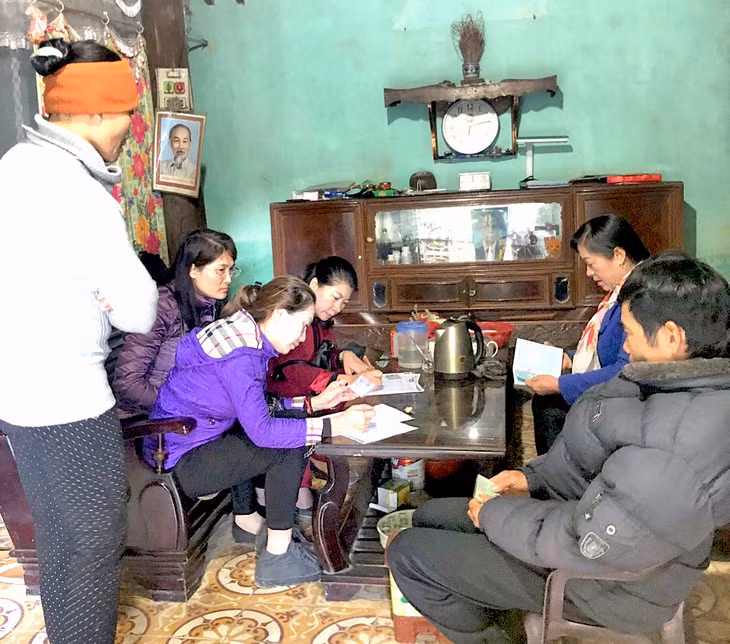 Cán bộ, nhân viên BHXH tuyên truyền BHYT cho các hộ dân xã Tân Dân, TP Hạ Long.