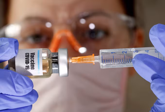 Y tá cầm một lọ được gắn nhãn vaccine Covid-19. Ảnh: Reuters.