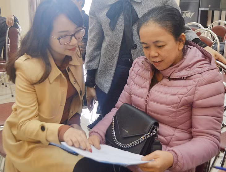Cán bộ Bưu điện hướng dẫn bà con nông dân phường Cẩm Phú (Cẩm Phả) các thủ tục tham gia BHXH tự nguyện vào tháng 12/2020. Ảnh: Dương Trường.