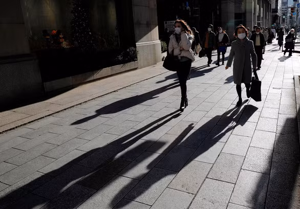 Người đi bộ qua một cửa hàng giữa đại dịch COVID-19 ở Tokyo, Nhật Bản ngày 25-12-2020 - Ảnh: REUTERS