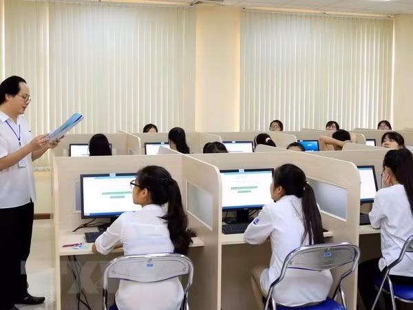 Giám thị phổ biến quy chế thi cho thí sinh trước giờ làm bài thi đánh giá năng lực môn Ngoại ngữ trên máy tính tại Đại học Quốc gia Hà Nội. (Ảnh: Quý Trung/TTXVN)
