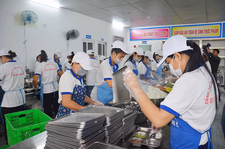 Nhân viên Công ty TNHH Thương mại Hải Hương chia suất ăn cho học sinh.