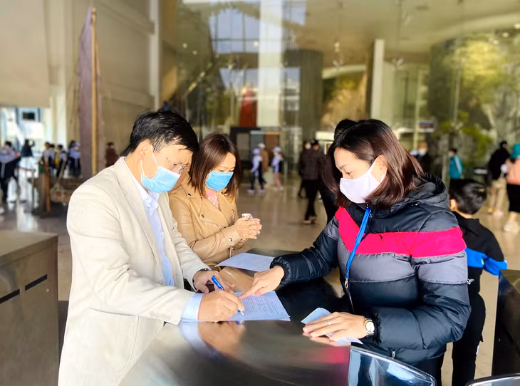 Nhân viên Bảo tàng Quảng Ninh hướng dẫn du khách khai báo y tế trước khi vào tham quan. Ảnh: Hoàng Nga