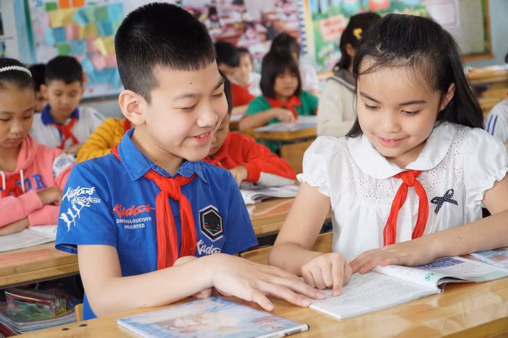 Dù bị khuyết tật nhưng Nguyễn Đăng Khôi (bên trái), Trường Tiểu học Trưng Vương (TP Uông Bí) vẫn rất nỗ lực, đạt thành tích cao trong học tập, được bạn bè yêu mến.