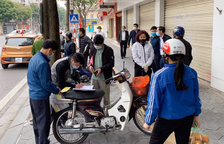 Đoàn công tác TP Hải Dương lập biên bản, nhắc nhở người dân không tập trung đông người, thực hiện cách ly xã hội, tháng 2/2021. Ảnh: Thành Đông