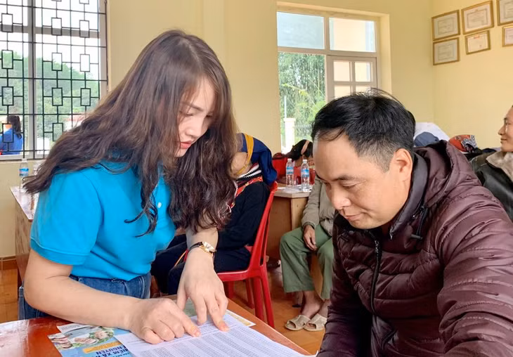 Cán bộ BHXH tỉnh hướng dẫn người dân thôn Khe Phương xã Kỳ Thượng (TP Hạ Long) thủ tục tham gia BHXH tự nguyện.