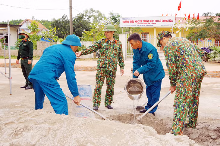 Cán bộ, chiến sĩ LLVT TP Cẩm Phả tham gia xây dựng củng cố xây dựng khuôn viên nhà văn hóa thôn Hà Tranh.