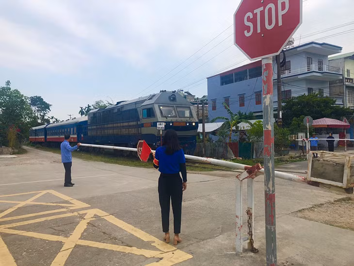 Nhân viên Trường Tiểu học Phương Đông B phối hợp với các lực lượng của phường đảm bảo ATGT khu vực đường sắt cho học sinh đi lại.