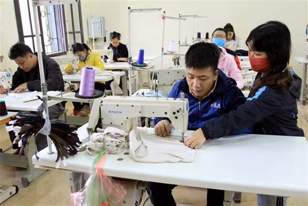 Các học viên học nghề may công nghiệp được giáo viên (là người khuyết tật) chỉ dạy tận tình tại Trung tâm dạy nghề (Hội Bảo trợ người khuyết tật và Bảo vệ quyền trẻ em tỉnh Thái Bình). (Ảnh: Thế Duyệt/TTXVN)