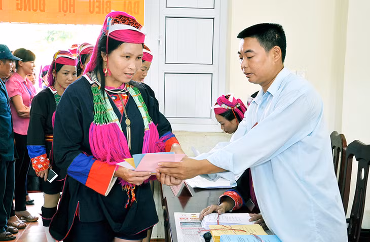 Anh Nịnh Văn Bằng, thành viên tổ bầu cử số 1, thôn Khe Tâm, xã Nam Sơn (Ba Chẽ) hướng dẫn cử tri đồng bào dân tộc Dao Thanh Y làm thủ tục bỏ phiếu.