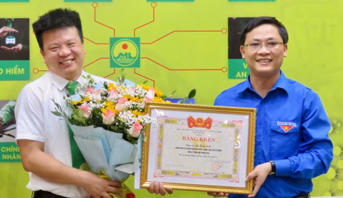 Phó bí thư Tỉnh Đoàn Thanh Hóa Hoàng Văn Thanh trao tặng bằng khen cho tài xế Sinh. Ảnh: Lam Sơn.