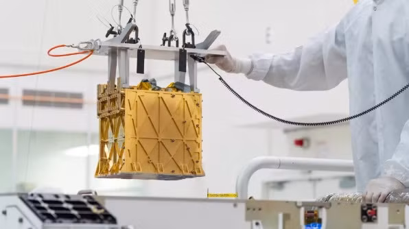 Kỹ thuật viên từ từ hạ MOXIE vào bụng tàu thăm dò Perseverance. Ảnh: NASA