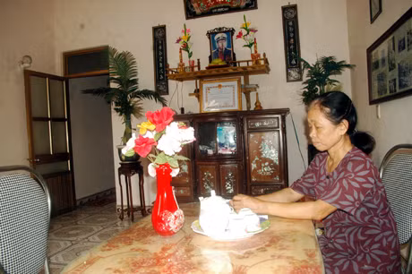 Chị Vũ Thị Hiệp bên bàn thờ chồng mình, Anh hùng - Liệt sĩ Nguyễn Công Bao.