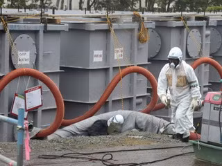  Một nhân viên TEPCO đang kiểm tra các thùng chứa nước thải tại nhà máy điện hạt nhân Fukushima - Ảnh: AFP 