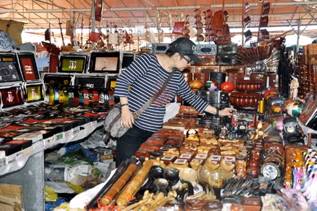 Khách du lịch xem gian hàng ở chợ đêm Hạ Long.