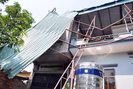 Gió to khiến mái tôn rộng vài chục m2 bị cuốn bay sang nhà lân cận.